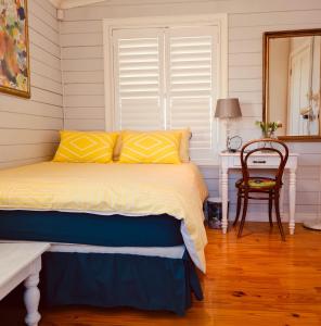 a bedroom with a bed and a table and a mirror at Exquisite chalet on private nature reserve in Wolseley +24 photos