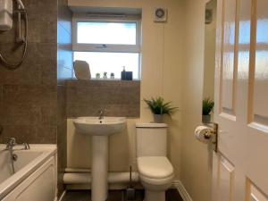 a bathroom with a toilet and a sink and a window at House - 10min to City Centre - Sleeps 4 - Parking in Birmingham +21 photos