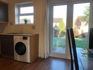 a kitchen with a washing machine in front of a window at House - 10min to City Centre - Sleeps 4 - Parking in Birmingham