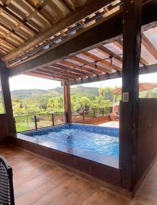 una gran piscina en una casa con una gran ventana en Pousada Cachoeira do Sol en Jaboticatubas