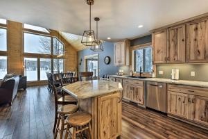 a kitchen with wooden cabinets and a large island at Lakefront Cottage in Iron River with 2 Porches! in Iron River