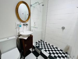 a bathroom with a sink and a toilet and a mirror at Goblin's Creek in St. Helena Bay