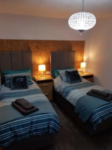 1 dormitorio con 2 camas y lámpara de araña en Saracens House en Preesall