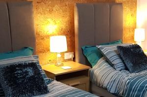1 dormitorio con 2 camas y mesita de noche con 2 lámparas en Saracens House en Preesall