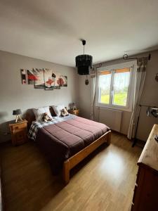 Un dormitorio con una cama grande y una ventana en haut-Jur'Accueillant en Saint-Laurent-en-Grandvaux