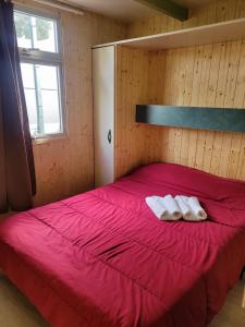 a bedroom with a large red bed with two white towels at Camping Costa Blanca in El Campello