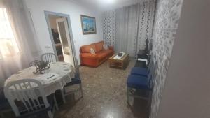 ein Wohnzimmer mit einem Tisch und einem Sofa in der Unterkunft PLANTA BAJA EN SANTA POLA in Santa Pola