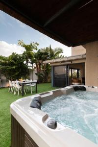 a hot tub in the backyard of a house at O&O Group - Huge Villa With Jacuzzi By The Beach in Rishon LeẔiyyon