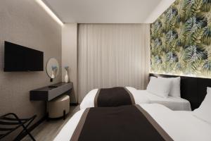 達霍克的住宿－DDK Hotel Duhok，酒店客房设有两张床和一台平面电视。