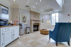 a kitchen with a fireplace and a blue chair at Spectacular Condo 2/2 @Ballston With Gym in Arlington