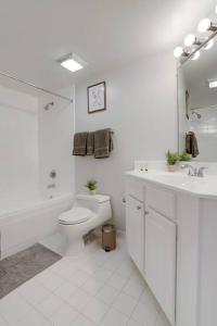 La salle de bains blanche est pourvue de toilettes et d'un lavabo. dans l'établissement Spectacular Condo 2/2 @Ballston With Gym, à Arlington