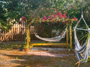 una hamaca en un jardín con flores y una valla en Casa Limon with HEATED POOL, en Sarasota