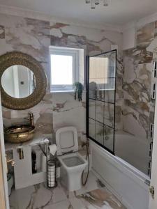 a bathroom with a toilet and a sink and a mirror at Modern 2 bedroom flat by Dover Port, Castle& Sea! in Kent