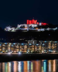 a large building lit up at night with red lights at Modern 2 bedroom flat by Dover Port, Castle& Sea! in Kent