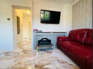 a living room with a red couch and a fire place at Modern 2 bedroom flat by Dover Port, Castle& Sea! in Kent