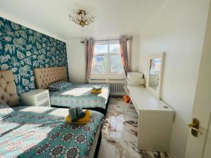 een kleine slaapkamer met 2 bedden en een bureau bij Modern 2 bedroom flat by Dover Port, Castle& Sea! in Kent