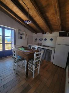 Il comprend une cuisine équipée d'une table en bois et d'un réfrigérateur. dans l'établissement Appartamento Rosmarino, à Acquedolci