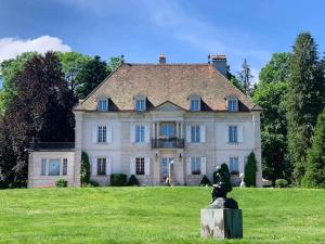 una casa grande con una estatua delante de ella en Balance appartment - Le Locle en Le Locle