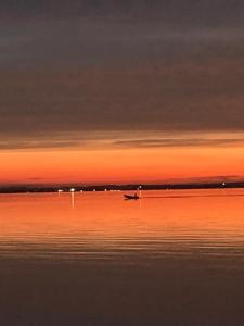 un bateau au milieu de l'eau au coucher du soleil dans l'établissement Boutique Hotel Bel Sito Wellness & Private SPA, à Bardolino