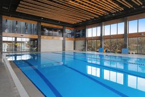 a large swimming pool with blue water in a building at DDK Hotel Duhok in Duhok