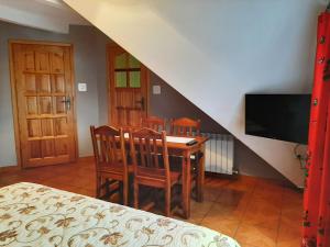 a dining room with a table and chairs and a tv at Kazkowa Koliba in Zakopane