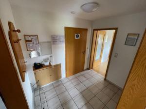 a hallway of a kitchen with a door and a tiled floor at Ferienwohnung Käppelehof in Schramberg