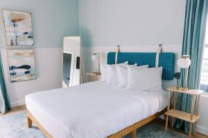 um quarto com uma cama branca e uma parede azul em Unit 124 - The Strand 2 Bed - Cation on the Guadalupe em New Braunfels