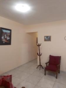 ein Wohnzimmer mit einem roten Stuhl und einer Wand in der Unterkunft Apartamentos Naomi in El Carmen