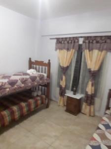 a bedroom with two beds and a window with curtains at Apartamentos Naomi in El Carmen