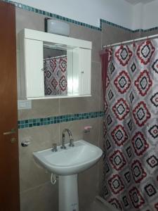 y baño con lavabo, espejo y cortina de ducha. en Apartamentos Naomi en El Carmen