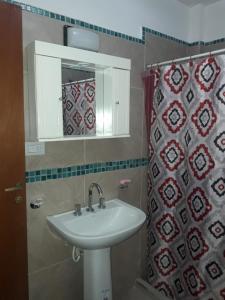 a bathroom with a sink and a mirror and a shower curtain at Apartamentos Naomi in El Carmen