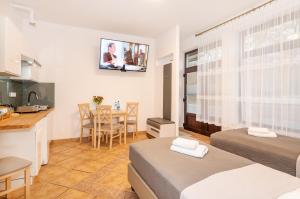 Cette chambre comprend deux lits, une cuisine et une table. dans l'établissement Apartamenty Plażowa 11, à Darłówko