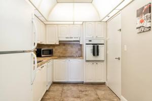 a white kitchen with white cabinets and a refrigerator at Luxury Stylish Oceanfront 2 bedroom 2 bathroom in HOLLYWOOD FL in Hollywood