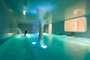 ニースにあるBoscolo Nice Hotel & Spaの水中の人々と一緒にプール