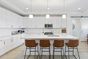 een keuken met witte kasten en een eiland met vier stoelen bij 405 The Harbor Condominiums in St Pete Beach