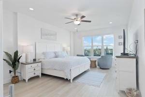 een witte slaapkamer met een bed en een plafondventilator bij 405 The Harbor Condominiums in St Pete Beach