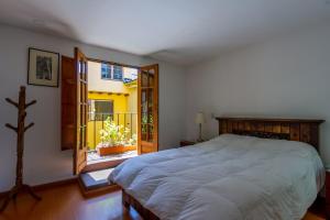 Un dormitorio con una cama grande y un balcón. en Apartaestudios La Candelaria, en Bogotá