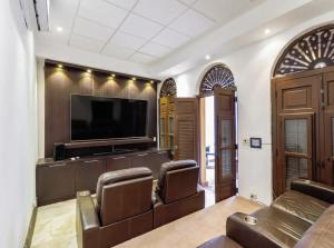 a living room with leather chairs and a flat screen tv at Old San Juan Rentals in San Juan