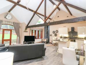 a living room with a large couch and a kitchen at Dale Cottage in Oldham