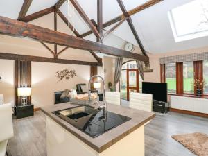 a kitchen with exposed beams and a living room at Dale Cottage in Oldham