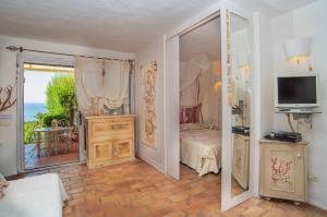 a bedroom with a bed and a tv and a window at La Casa delle Conchiglie in Capo Coda Cavallo