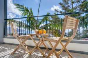 una mesa y sillas en un balcón con vistas al océano en Vila Camacho Guest House, en Funchal