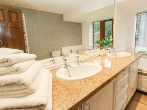 ein Badezimmer mit zwei Waschbecken und einem großen Spiegel in der Unterkunft Moor Cottage in Oldham