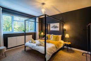 1 dormitorio con cama con dosel y sábanas amarillas en Lake View Retreat, Pet Friendly, Free Parking, Lake View, Golf nearby, en Bowness-on-Windermere