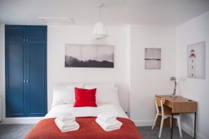 um quarto com uma cama com almofadas vermelhas e uma secretária em Special Offer! Lovely studio - ZONE 1 - Hyde Park em Londres