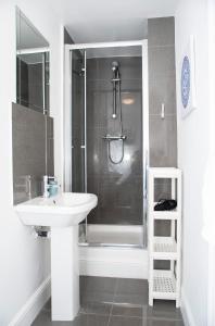 uma casa de banho branca com um chuveiro e um lavatório. em Special Offer! Lovely studio - ZONE 1 - Hyde Park em Londres