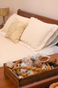 a basket of rocks on a table next to a bed at Aktea coastal village home in Kalymnos