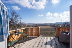 eine Holzterrasse mit einem Tisch und Stühlen darauf in der Unterkunft Naphegy Kuckó in Écs