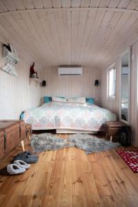 a bedroom with a bed and a wooden floor at Naphegy Kuckó in Écs