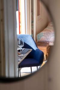 einen blauen Stuhl und einen Tisch mit einem Glas Wein in der Unterkunft Naphegy Kuckó in Écs